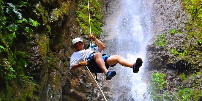 waterfall rappelling down a rainforest waterfall in Costa Rica