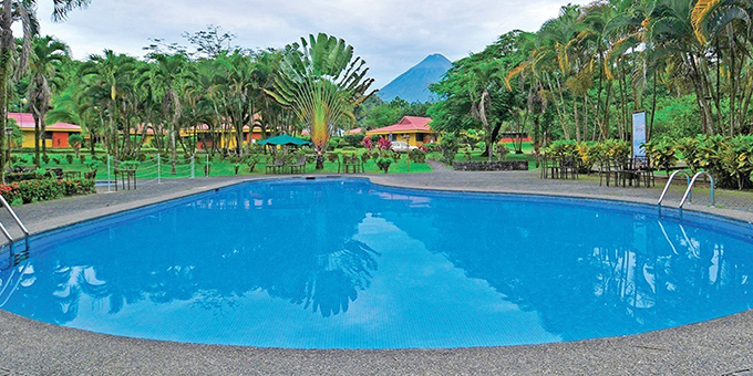 Arenal Country Inn in La Fortuna, Costa Rica, is a cozy and charming economical hotel nestled amidst the stunning natural beauty of the Arenal Volcano region. The inn offers comfortable and well-appointed accommodations, including spacious rooms and bungalows, designed to provide a relaxing and peaceful stay for guests. Each room is tastefully decorated and equipped with modern amenities for added convenience. The inn features lush gardens and a lovely outdoor swimming pool, providing a serene setting to unwind and enjoy the picturesque surroundings. The on-site restaurant offers a delightful dining experience with a menu that showcases local flavors and fresh ingredients. The inn's location offers easy access to explore the nearby Arenal Volcano National Park, hot springs, and an array of outdoor activities such as hiking, canopy tours, and wildlife spotting. With its warm hospitality, tranquil ambiance, and convenient location, Arenal Country Inn offers a comfortable and authentic Costa Rican experience for guests visiting La Fortuna. Guests of Arenal Country Inn will enjoy amenities such as outdoor swimming pool, lounge chairs, bar, restaurant, entertainment area, tour desk, internet access, tropical gardens, volcano views, and parking facilities.