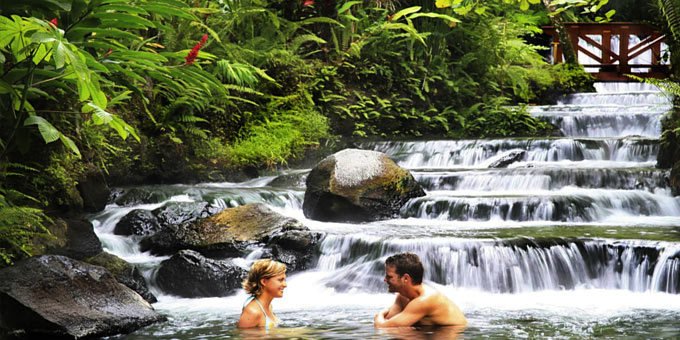 A couple indulging in the soothing hot springs at Tabacon Resort in La Fortuna