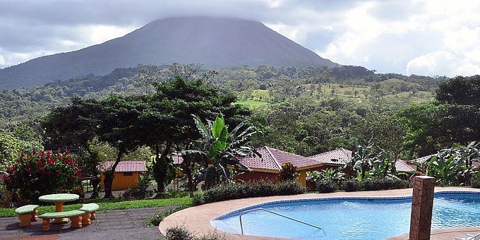 Hotel Miradas Arenal in La Fortuna, Costa Rica, is an economy-friendly boutique hotel nestled amidst the stunning natural beauty of the Arenal region. The hotel offers affordable and stylish accommodations, including well-appointed rooms and spacious suites, all thoughtfully designed to provide a cozy and relaxing stay. Each room features modern amenities and balconies or terraces with breathtaking views of the Arenal Volcano or the surrounding rainforest. The hotel's inviting swimming pool and lush gardens create a serene atmosphere for guests to unwind and soak up the tranquility of the surroundings. The on-site restaurant serves delicious Costa Rican cuisine, showcasing the flavors of the region. The hotel's location offers easy access to explore the nearby Arenal Volcano National Park, hot springs, and a range of adventure activities such as hiking, zip-lining, and horseback riding. With its warm hospitality, stunning views, and convenient location, Hotel Miradas Arenal is a perfect choice for budget-conscious travelers seeking a peaceful and nature-filled escape in La Fortuna, Costa Rica. Hotel amenities include swimming pool,  breakfast bar, trails, laundry service, and WiFi internet in the common  area