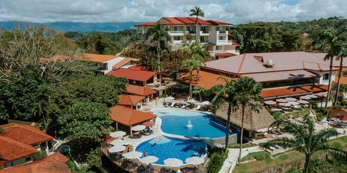 Hotel Parador Resort and Spa, nestled in the captivating Manuel Antonio, Costa Rica, is a premier eco-luxury destination where nature and comfort harmoniously coexist. Surrounded by lush tropical rainforests and overlooking the Pacific Ocean, our resort offers an enchanting retreat for discerning travelers. Immerse yourself in the tranquility of our elegantly appointed rooms and suites, each designed to showcase breathtaking views and provide a haven of relaxation. Indulge in culinary delights at our award-winning restaurants, where farm-to-table cuisine meets exquisite flavors. Unwind by our swimming pools, surrounded by lush gardens, or pamper yourself with rejuvenating treatments at our renowned spa. Discover the wonders of Manuel Antonio National Park, just minutes away, with its pristine beaches and abundant wildlife. With a commitment to sustainability and exceptional service, Hotel Parador Resort and Spa invites you to experience the perfect blend of luxury, nature, and warm Costa Rican hospitality in Manuel Antonio. Guests should be aware that the hotel is located on a bluff and not surrounded by beaches. One can walk down a hill to nearby Playa Biesanz. Hotel amenities include swimming pools, restaurants and bars, a spa, fitness center, tennis court, gift shop, conference room, a computer station, self-service washing and drying machines, tropical gardens, jungle trails, and WiFi in most public areas and rooms.