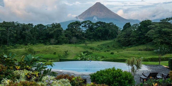 Arenal Lodge, located near Lake Arenal in Costa Rica, is a tranquil mountain retreat surrounded by lush rainforest and boasting breathtaking views of the Arenal Volcano. The lodge offers cozy and comfortable accommodations, including rooms, chalets, and suites, that provide a peaceful haven for guests. The spacious rooms feature rustic charm and modern amenities, ensuring a comfortable stay. The lodge's expansive grounds offer opportunities for outdoor adventures, including hiking trails, horseback riding, and birdwatching. Guests can also enjoy a refreshing swim in the outdoor pool or relax in the hot tub while taking in the stunning natural scenery. The lodge's restaurant serves delicious meals prepared with fresh local ingredients, and guests can unwind with a drink at the bar. With its serene location, close proximity to Lake Arenal, and the majestic presence of the Arenal Volcano, Arenal Lodge provides a tranquil retreat where guests can immerse themselves in nature's beauty and enjoy a peaceful getaway in Costa Rica. Lodge amenities include a swimming pool, jacuzzi, internet access, restaurant, bar, fitness rooms, steam room, tropical gardens, butterfly garden and nature trails. Important to mention sauna is out of service until further notice.