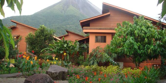 Hotel Silencio del Campo in La Fortuna, Costa Rica, is a charming and peaceful retreat nestled in the lush countryside, offering a serene and immersive experience. The hotel features cozy and comfortable bungalows that blend rustic charm with modern amenities. Surrounded by beautiful gardens and tropical landscapes, guests can enjoy a tranquil atmosphere and stunning views of the Arenal Volcano. The hotel offers an outdoor swimming pool and a hot springs-fed pool, providing the perfect spot to relax and unwind. Guests can also indulge in rejuvenating spa treatments or take part in exciting activities such as hiking, horseback riding, and exploring the nearby Arenal Volcano National Park. The on-site restaurant serves delicious local cuisine, allowing guests to savor the flavors of Costa Rica. With its tranquil setting, friendly staff, and proximity to natural attractions, Hotel Silencio del Campo offers a peaceful escape for those seeking relaxation and connection with nature in La Fortuna, Costa Rica. Amenities of the lodge include a spa, swimming pool, hot springs, tropical gardens, working farm, restaurant, breakfast, Jacuzzi, and WiFi in some common areas.