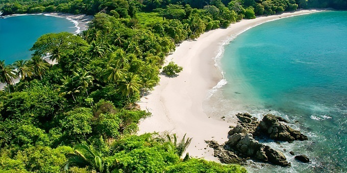 A couple walks on Playa Manuel Antonio inside of the national park