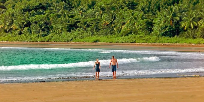 A couple walks the beach in Uvita