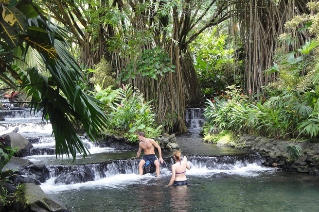 A couple enjoys Tabacon hot springs at the base of Arenal Volcano.